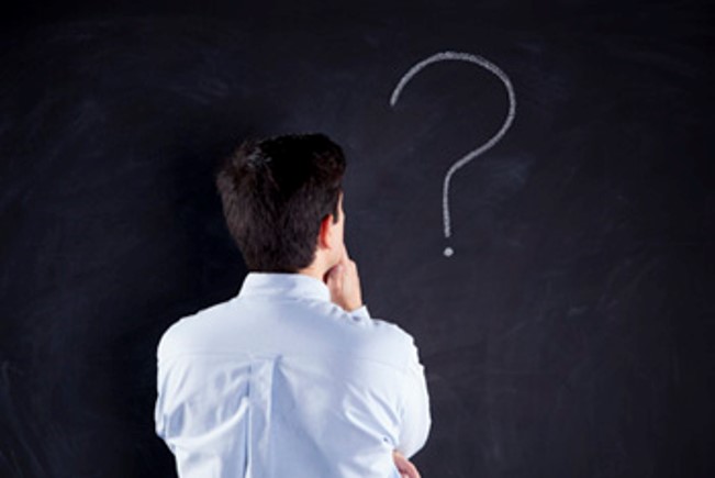 a man staring at a question mark drawn on a chalkboard